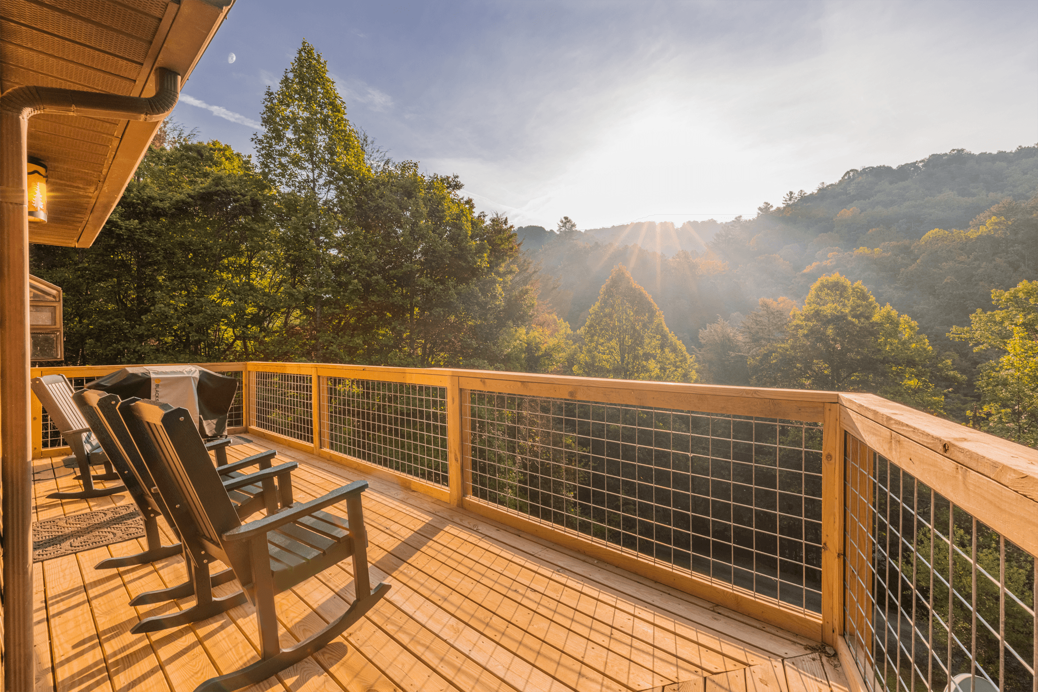 Spacious covered deck at The Teddy with comfortable outdoor seating and panoramic views of the Smoky Mountain forest.