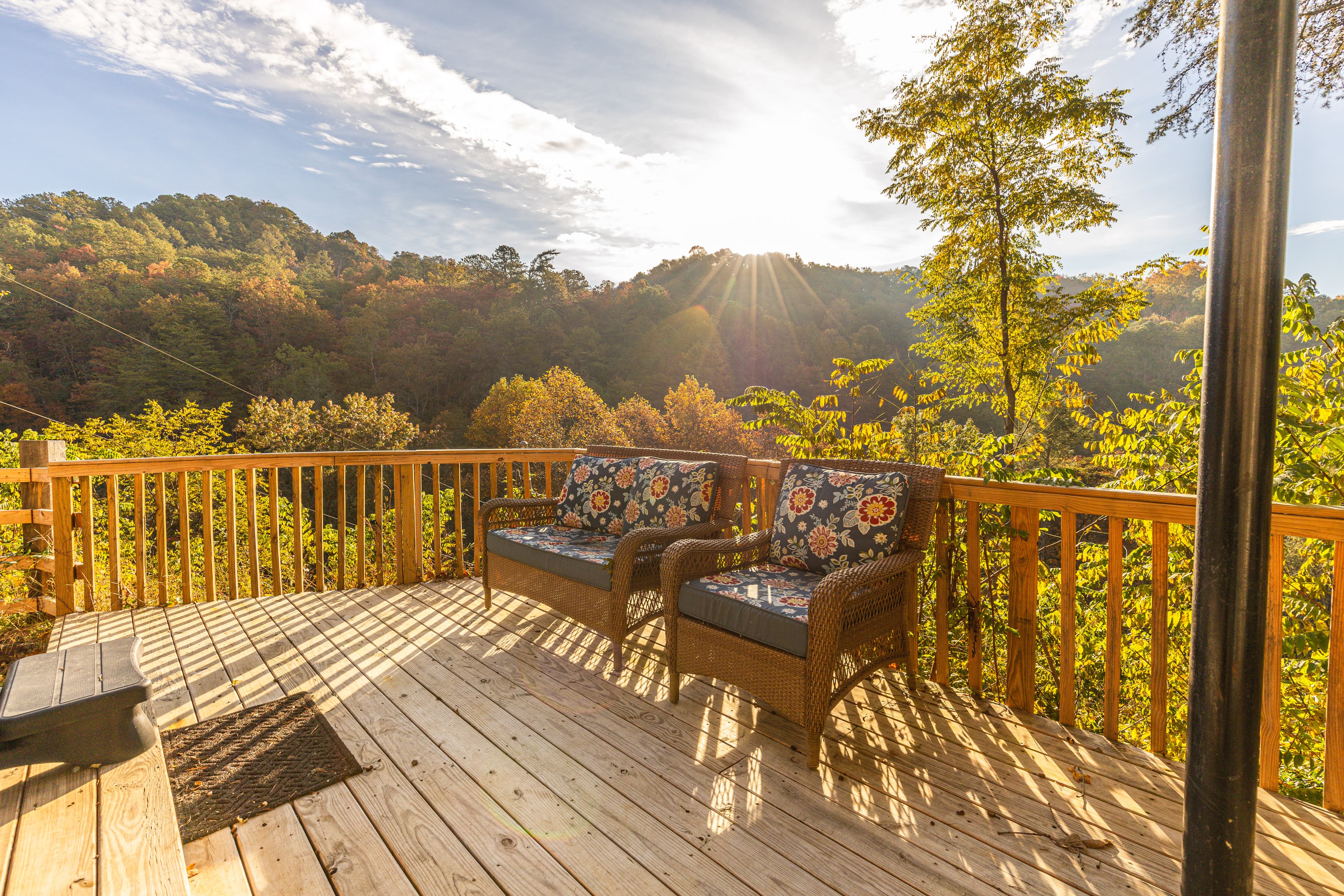 The expansive timber-frame deck at Livingstone Great House, featuring a luxury hot tub and comfortable outdoor lounge seating overlooking a panoramic mountain ridgeline.