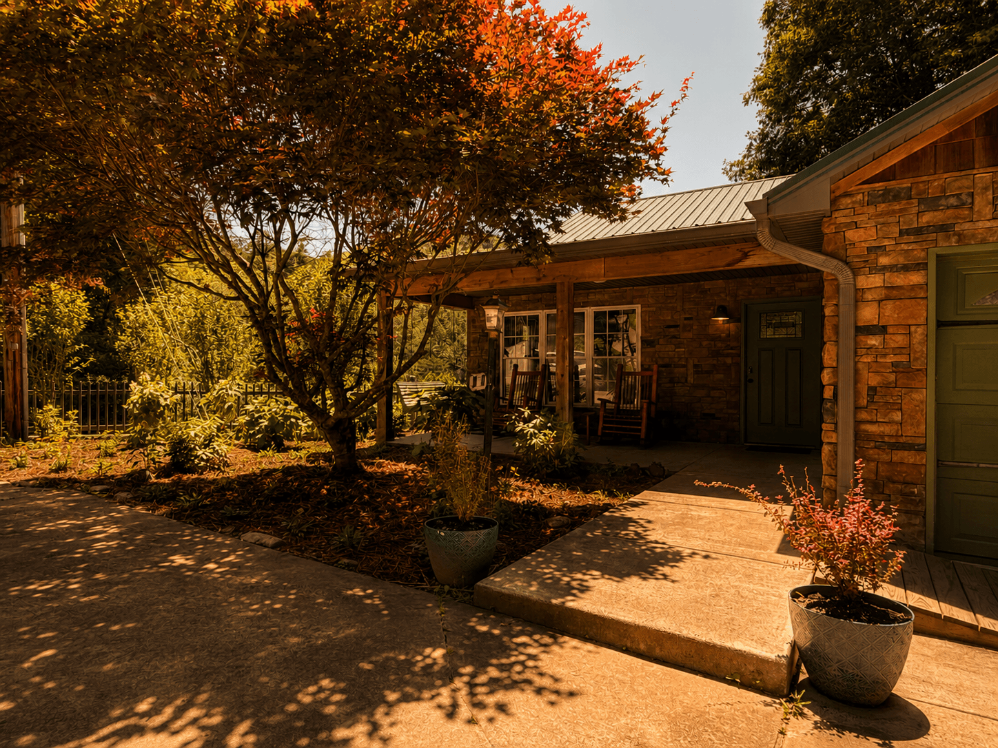 Welcoming front porch and landscaped entrance of Livingstone Station Lodge at Three Little Bears Retreat in Bryson City, North Carolina.