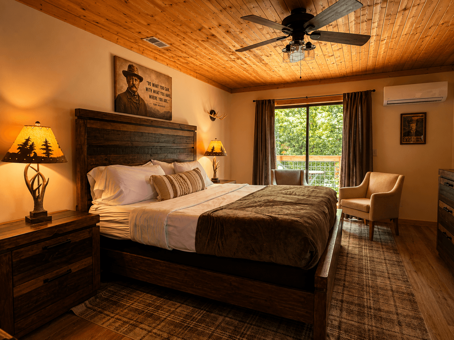 Spacious master bedroom in The Teddy with a king-sized log bed, luxury linens, and private access to the balcony at Frontier Hall.
